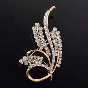 Vue macro d'une broche en épi de blé doré avec strass en cristal sur fond noir