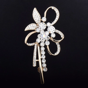 Détail de la broche fleur dorée avec des cristaux étincelants et design de ruban élégant