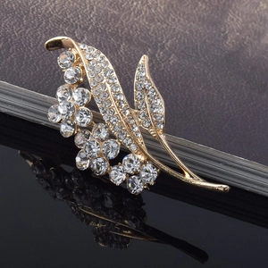 Detailed macro view of crystal flower brooch with gold plating and sparkling rhinestones