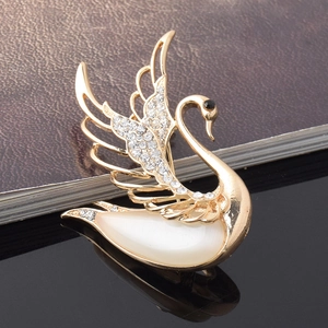 Close-up of elegant swan brooch featuring opal stone and shimmering rhinestones in detail