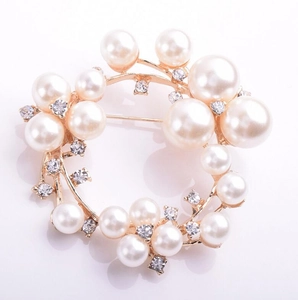 Elegante broche circular de perlas con base dorada y diamantes de imitación brillantes