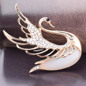 Elegant gold swan brooch with white rhinestones and a large opal stone center