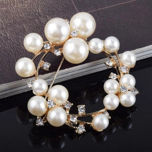 Elegante broche redondo de perlas doradas con cristales brillantes en fondo oscuro de lujo