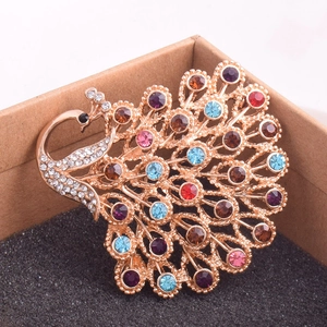 Gros plan détaillé d'une broche paon en cristal coloré avec finition or rose