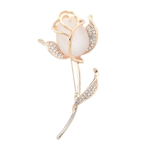 Broche rose dorée élégante avec pierre œil-de-chat blanche et strass brillants sur fond blanc