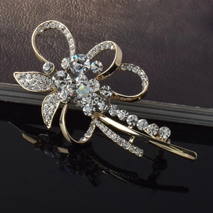 Détails de la barrette à fleurs dorée avec strass en cristal sur surface réfléchissante