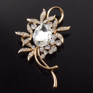Détail de la broche fleur avec cristal ovale et pétales en strass sur fond noir