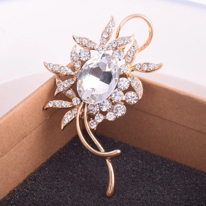 Détail de la broche fleur or rose avec cristal ovale et pétales en strass étincelants