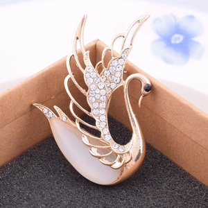 Detail of elegant gold swan brooch with opal body and sparkling rhinestone accents