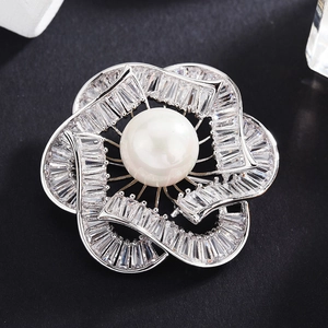 Élégante broche fleur argentée avec grande perle blanche et pétales en zircon sur fond noir