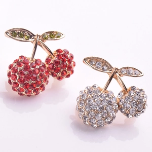 Detailed close-up of cherry brooch with red crystals and gold-plated leaf details