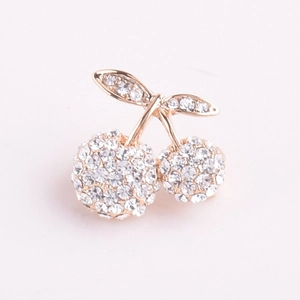 Detailed macro view of cherry brooch with sparkling rhinestones and rose gold plating