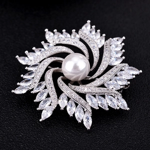 Luxurious crystal zircon windmill brooch with a large white pearl center on black leather