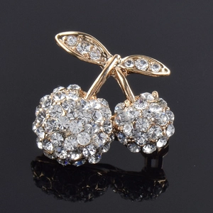 Sparkling cherry brooch with clear rhinestones on gold base shown on black background