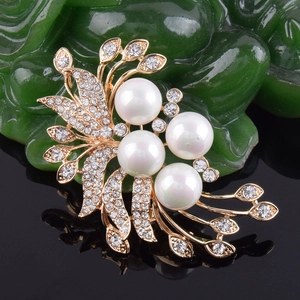 Vue macro d'une broche florale de luxe avec perles blanches et strass sur base or