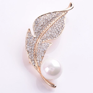 Détail de la broche feuille avec cristaux micro-pavés et une grande perle blanche