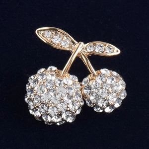 Detailed view of luxury cherry brooch with sparkling rhinestones and gold alloy plating