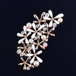 Détail macro de la broche fleur émaillée en or rose avec perles et cristaux fins