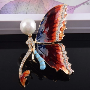 Macro detail of mermaid butterfly brooch with large pearl and blue enamel wings