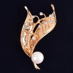 Elegante spilla a forma di mughetto dorata con cristalli e una perla bianca lucida