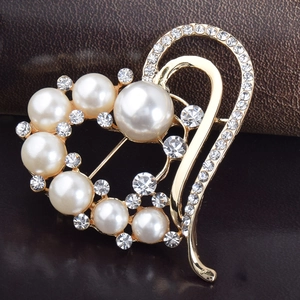 Élégante broche en forme de cœur avec perles et cristaux sur base dorée, vue à 45 degrés