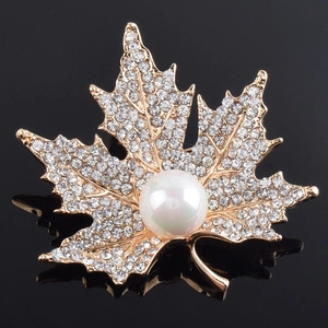 Elegant maple leaf brooch with sparkling crystals and a white pearl on golden base