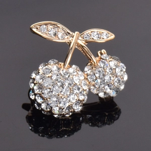Detailed view of luxury cherry brooch with red crystals and gold-plated alloy base