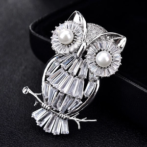 Elegante spilla a gufo in argento con pavé di zirconi e dettagli in perle bianche su ramo