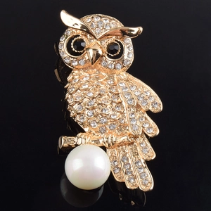 Exquisite goldene Eulenbrosche mit funkelnden Kristallen und großer Perle auf schwarzem Grund