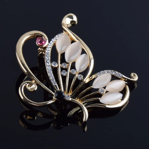 Détail macro de la broche papillon avec pierres oeil de chat et strass sur surface noire