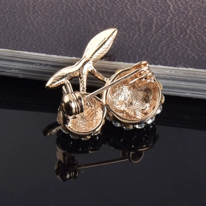 Macro detail of the cherry brooch back with golden pin and secure round clasp
