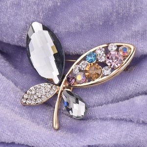 Macro view of crystal butterfly brooch featuring colorful rhinestones on purple velvet