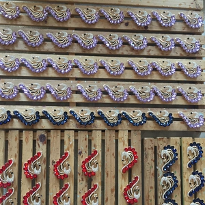 Dettaglio di spille in cristallo a forma di cigno in vari colori su un supporto di produzione