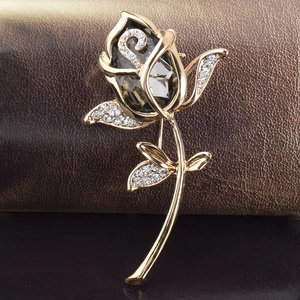 Makro-Detail der goldenen Rosenbrosche mit dunkelgrauem Kristall und weißen Strasssteinen