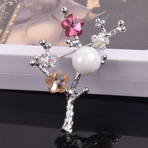 Detail of silver branch brooch with white pearl and multicolored crystal floral accents