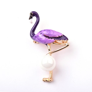 Κομψή χρυσή καρφίτσα φλαμίνγκο με μωβ σμάλτο και μαργαριτάρι σε λευκό φόντο