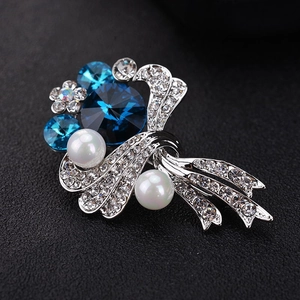 Close-up of luxury bouquet brooch with blue crystals, pearls, and sparkling rhinestones