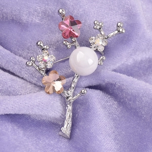 Elegant branch brooch with white pearl and colorful crystals on purple velvet background