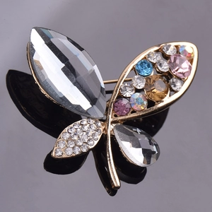 Elegant gold butterfly brooch with grey crystals and colorful rhinestones on dark mirror