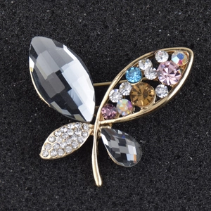 Detail of elegant butterfly brooch with faceted grey gemstones and colorful rhinestones