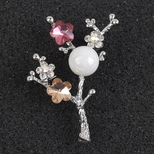 Detail of silver branch brooch with crystal flowers and a large white pearl center