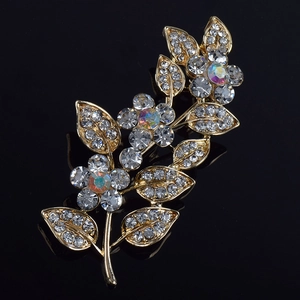Détail macro de la broche feuille avec strass en cristal et monture florale dorée
