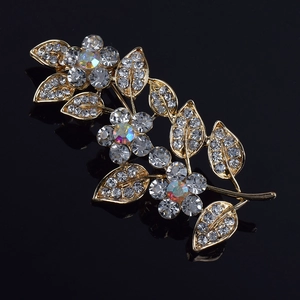 Gros plan détaillé d'une luxueuse broche fleur dorée avec des strass en cristal brillants