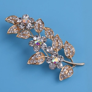 Détail de la broche feuille avec cristaux clairs et strass floraux irisés étincelants