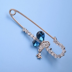 Elegant gold bow safety pin brooch with blue teardrop crystals and sparkling rhinestones