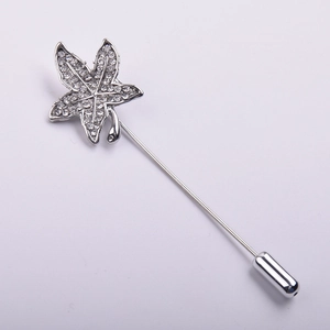 Detailed macro view of silver maple leaf brooch with sparkling pavé crystals and long pin