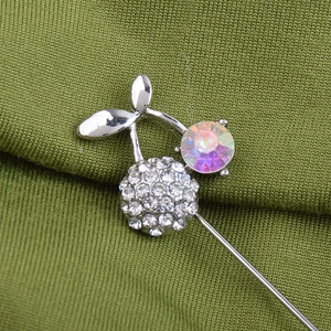 Elegant cherry brooch pin with sparkling AB crystals and rhinestones on green fabric