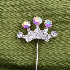 Vue détaillée de la broche couronne avec strass blancs et cristaux AB sur tissu vert