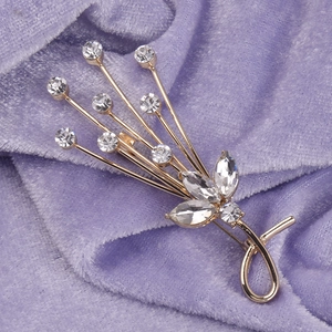 Sparkling crystal flower brooch with gold plating on premium purple velvet background