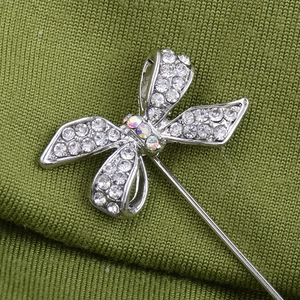 Broche nœud argentée pour hommes et femmes avec strass sur fond vert texturé